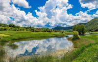 a river in the middle of a green field with clouds at Gorgeous Home In Slunj With Kitchen in Slunj