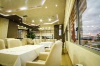 a dining room with white tables and white chairs at Hotel Oasis in Podgorica