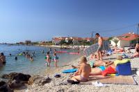 a group of people on the beach at the water at Apartments with a parking space Bibinje, Zadar - 5753 in Bibinje