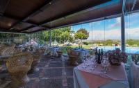 a restaurant with tables and wine glasses and a pool at Hacienda el Santiscal in Arcos de la Frontera