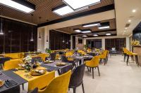 Un comedor con mesas y sillas amarillas. en EMAR HOTEL & SPA, en Sapareva Banya