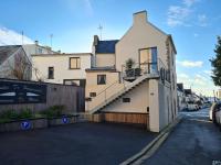 a white house with a staircase on the side of it at Les Suites de Bougainville in Concarneau