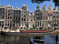 ein Boot im Wasser vor den Gebäuden in der Unterkunft Canal Hideaway in Amsterdam