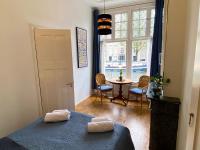 ein Schlafzimmer mit einem Bett und einem Tisch und einem Fenster in der Unterkunft Canal Hideaway in Amsterdam