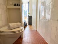 ein Badezimmer mit Toilette und Fliesenboden in der Unterkunft Canal Hideaway in Amsterdam