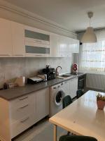 a kitchen with white cabinets and a table at Apartament spatios, mobilat si utilat complet in Floreşti