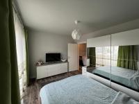 a bedroom with two beds and a flat screen tv at Apartament spatios, mobilat si utilat complet in Floreşti