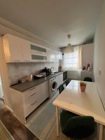 a kitchen with white cabinets and a table and a dining room at Apartament spatios, mobilat si utilat complet in Floreşti