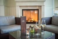 dos copas de vino en una mesa con chimenea en Strandhotel Glücksburg, en Glücksburg