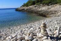 a stack of rocks on a rocky beach near the water at Studio Rukavac 8863a in Rukavac