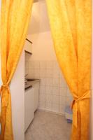 a bathroom with a yellow curtain in a kitchen at Studio Rukavac 8863a in Rukavac