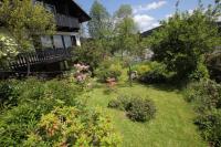 Un jardín con flores y plantas frente a una casa. en Haus Buron, en Titisee-Neustadt