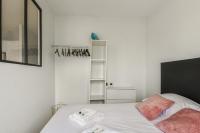 a white bedroom with a bed and a shelf at Beautiful apartment with a balcony in the heart of Lille - Welkeys in Lille