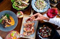 a table with plates of food and a person holding a sandwich at InterContinental Perth City Centre by IHG in Perth
