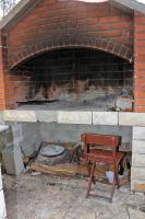 un horno de ladrillo con una silla delante en Apartments by the sea Bibinje, Zadar - 5786, en Bibinje
