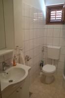 a bathroom with a white toilet and a sink at Apartment Seline 11197b in Starigrad
