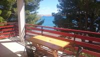 a picnic table on a balcony with a view of the water at Apartment Seline 11197b in Starigrad