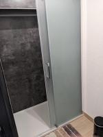 a shower stall with a glass door in a bathroom at Lodge du Léman in Sciez