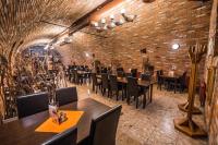 Un restaurante con mesas y sillas y una pared de ladrillos. en Penzión SESSLER ***, en Trnava