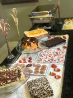 een tafel met veel verschillende soorten gebak en desserts bij Aquarius Hotel Flat Residence in Santa Cruz do Sul