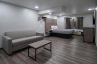 una sala de estar con un sofá y una cama en Americas Best Value Inn and Suites Lake Charles, en Lake Charles