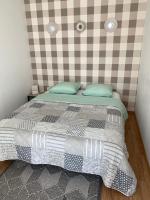 a bedroom with a bed with a checkered wall at Studio indépendant Lisieux in Lisieux