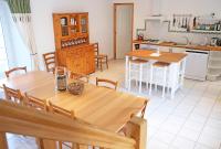a kitchen and dining room with a wooden table at Lescoat-le petit paradis in Plestin-les-Grèves