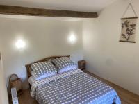 a bedroom with a bed with blue and white sheets at Vue du chateau a La Petite Ferme d&#39;Alpacas in Sanzay