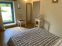a bedroom with a bed and a window and a chair at Vue du chateau a La Petite Ferme d&#39;Alpacas in Sanzay