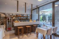 Un restaurante con un mostrador, mesas y sillas. en Hotel Eleven, en Petrovac na Moru