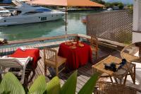 a table and chairs on a deck with a boat at Angra Boutique Hotel in Angra dos Reis