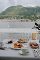 a table with plates of food and cups of coffee at Ah Porticcioli Boutique Apartments in San Felice del Benaco