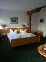 a bedroom with a large bed with white sheets at Hotel am Schloß in Schwerin