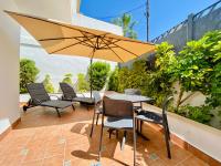 a patio with a table and chairs and an umbrella at Hotel Apartamentos Marina Luz in Chipiona