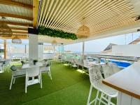 a restaurant with a pool and tables and chairs at Hotel Apartamentos Marina Luz in Chipiona