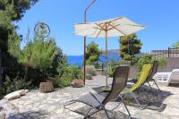 a patio with two chairs and an umbrella at Apartment Okrug Donji 16657b in Okrug Donji