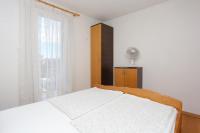 a white bedroom with a bed and a window at Apartment Okrug Donji 16657b in Okrug Donji