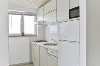 eine weiße Küche mit weißen Schränken und einem Waschbecken in der Unterkunft Apartments with a parking space Vir - 18581 in Vir