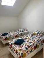 two beds sitting next to each other in a room at Duplex près de Nantes in Thouaré-sur-Loire