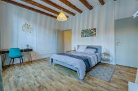ein Schlafzimmer mit einem Bett und einem blauen Stuhl in der Unterkunft La Ballerine - Baby foot - Centre historique in Romans-sur-Isère
