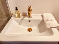 a bathroom sink with a gold faucet and a towel at Manoir du Suquet in Bardou
