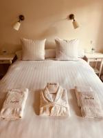 a white bed with two towels on top of it at Manoir du Suquet in Bardou