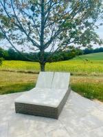 a white chair sitting on a patio under a tree at Manoir du Suquet in Bardou