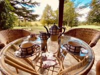 a glass table with four tea cups on top of it at Manoir du Suquet in Bardou