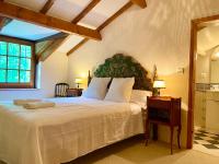 a bedroom with a large white bed and a window at Manoir du Suquet in Bardou