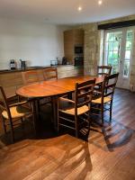 a wooden table and chairs in a kitchen at Manoir du Suquet in Bardou