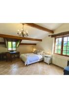 a bedroom with a bed and a table and windows at Manoir du Suquet in Bardou