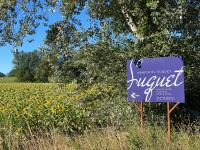 a purple sign in front of a field of flowers at Manoir du Suquet in Bardou