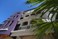 a building with a purple roof and a palm tree at Queen Love Homestay in Hualien City