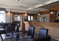 a restaurant with tables and chairs and a bar at Wigram Hotel in Christchurch